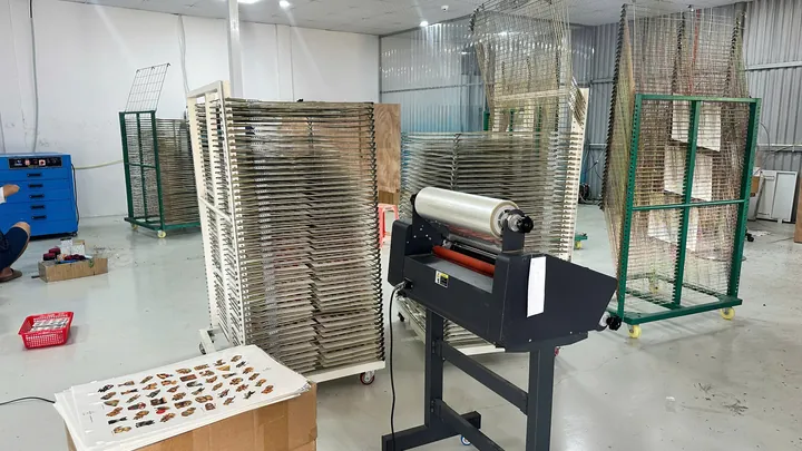 Thiết bị cán màng và giá phơi tại xưởng hình xăm dán